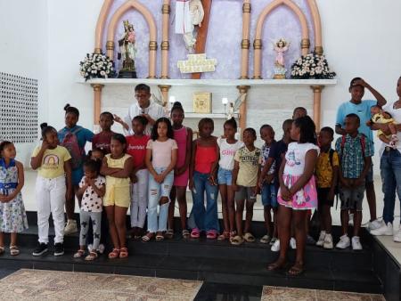 Kinder mit dem Priester am Altar, dahinter liegt der Katechetiksaal