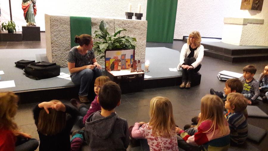 Kinder beim Fiire mit de Chline sitzen beim Altar